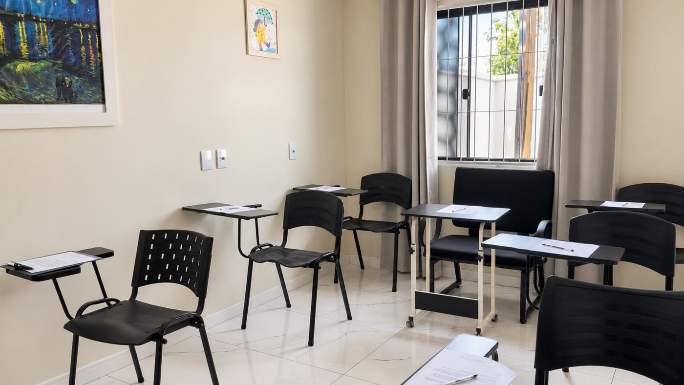 Sala de aplicação coletiva de testes psicológicos, com carteiras individuais, na Clínica PsicoVivendo